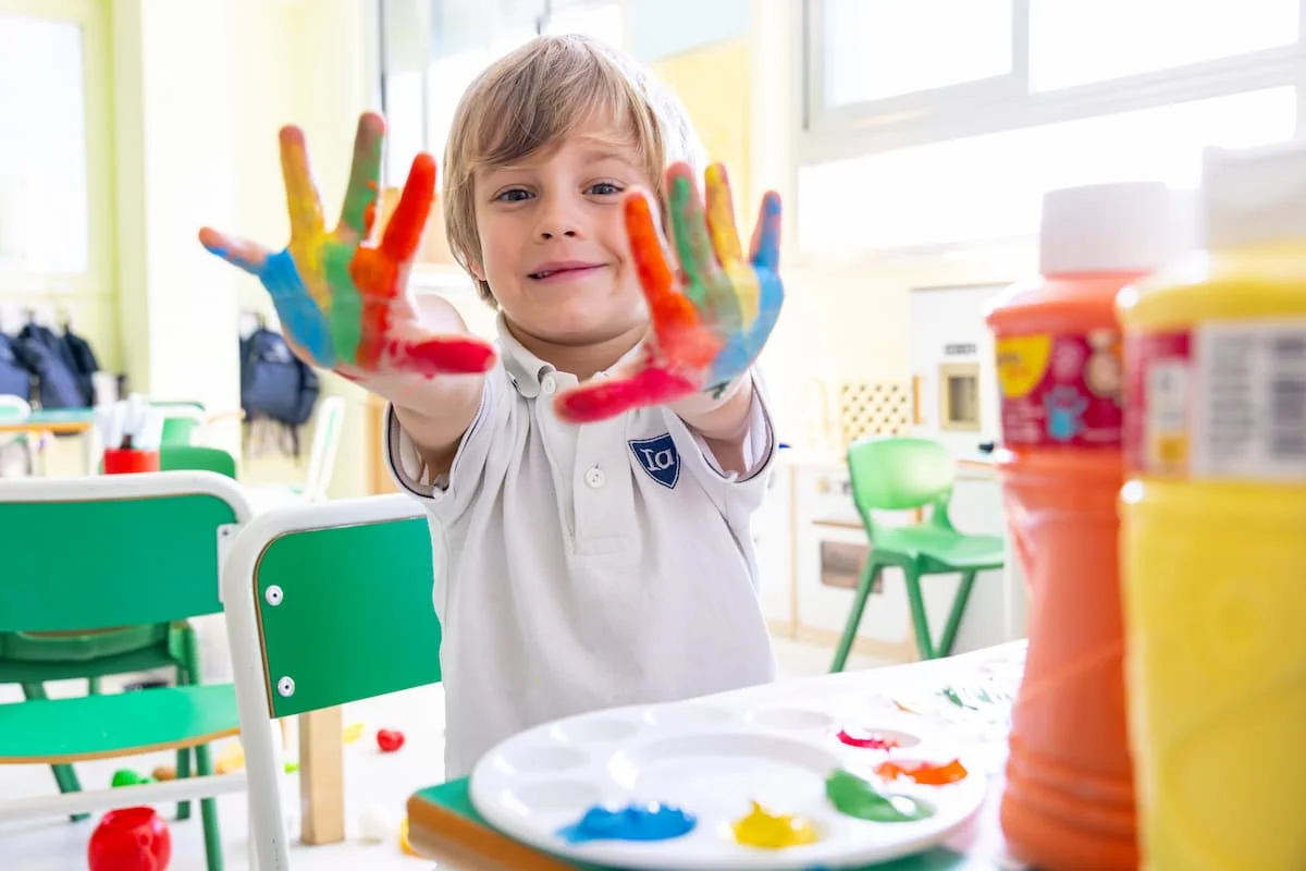 Early years child showing coloured hands 